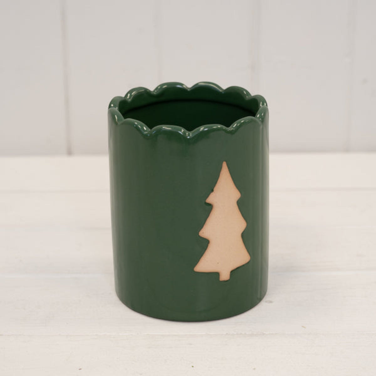 Green Christmas tree pot on a white wooden shelf