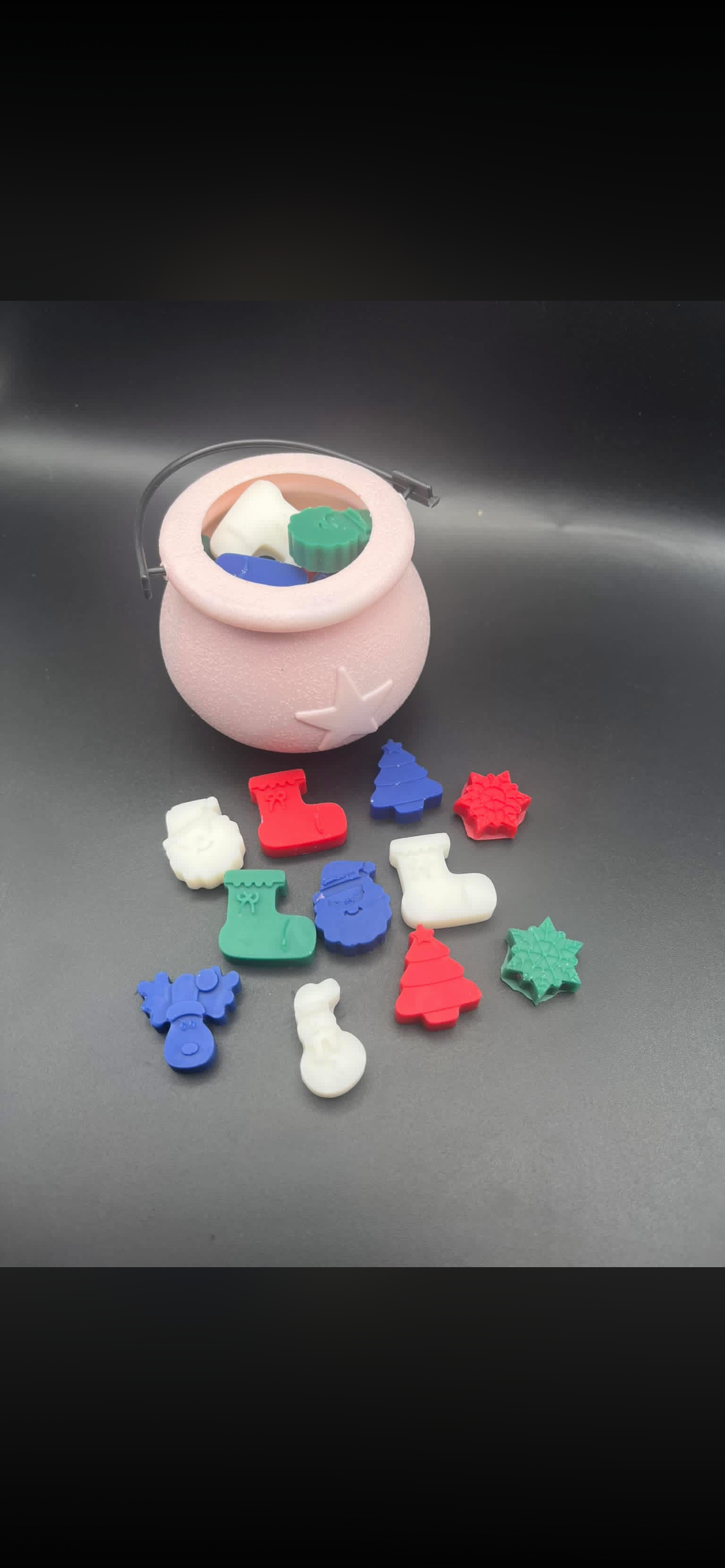 Pink bucket filled with Christmas-shaped wax melts including Santas, trees, stockings and snowmen