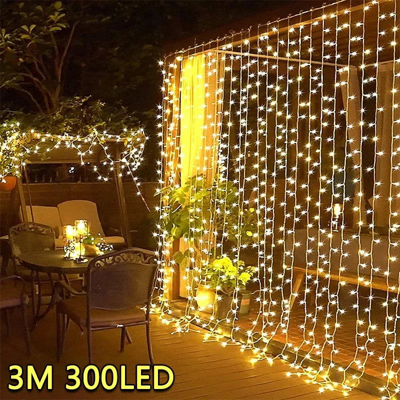 3m x 3m LED curtain fairy lights glowing warm white over a garden patio at night