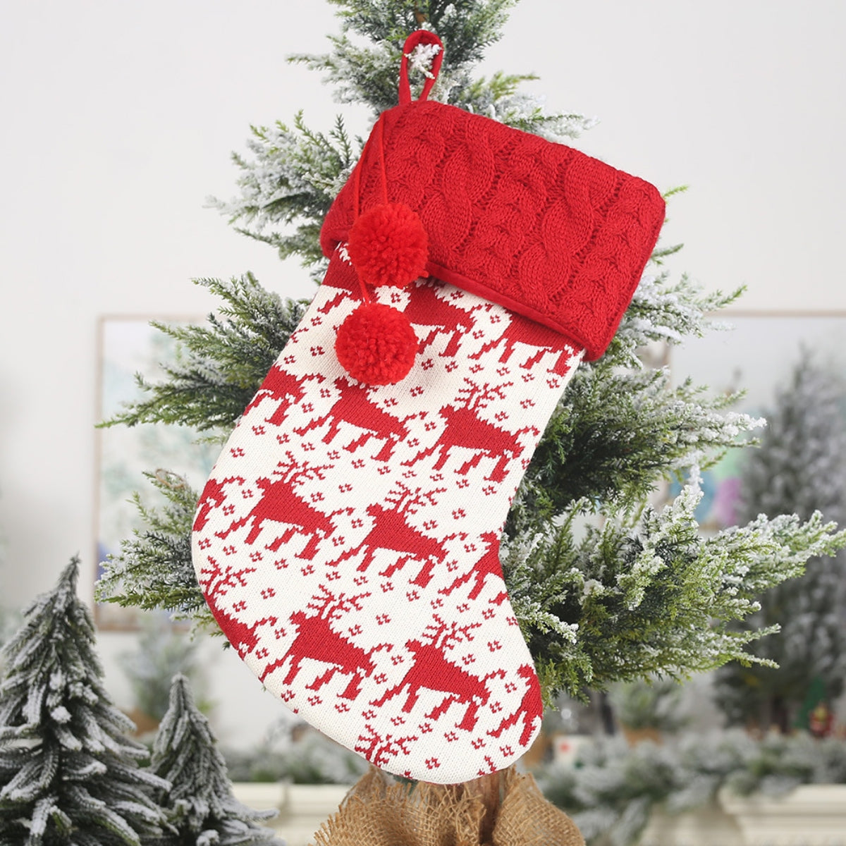 Red and white knitted reindeer Christmas stocking with pom-poms