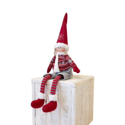 Fabric Christmas boy doll in red felt hat and red Fair Isle-style jumper sitting on a wooden crate