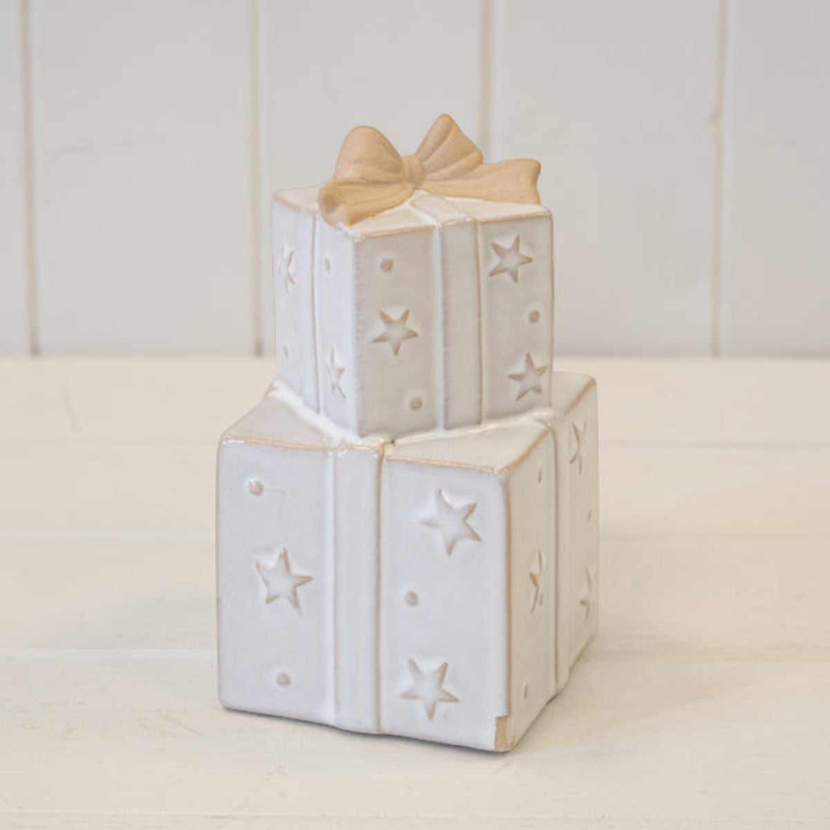Stacked ceramic Christmas presents ornament on a white shelf
