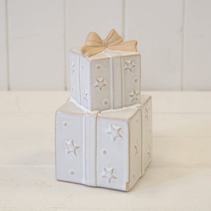 Stacked ceramic Christmas presents ornament on a white shelf