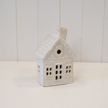 LED ceramic Christmas house on a white wooden shelf