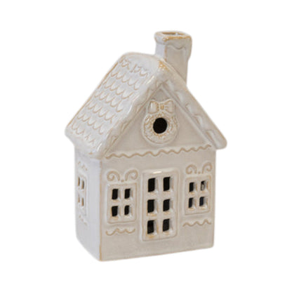 Cream ceramic Christmas house with scalloped roof, wreath window and cut-out windows