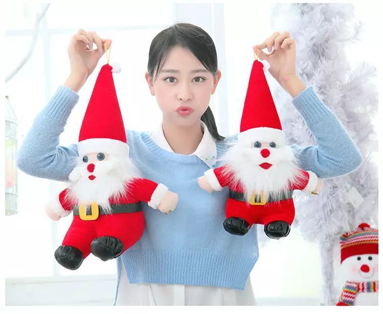 Two small Santa Claus plush toys held up by their hats