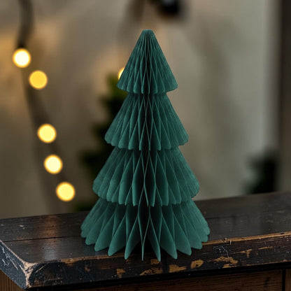 Dark green honeycomb paper Christmas tree on a wooden sideboard with fairy lights