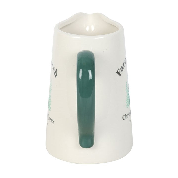 Cream ceramic Christmas jug seen from the green handle side