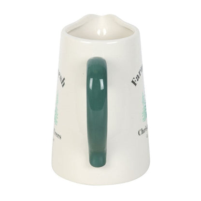 Cream ceramic Christmas jug seen from the green handle side
