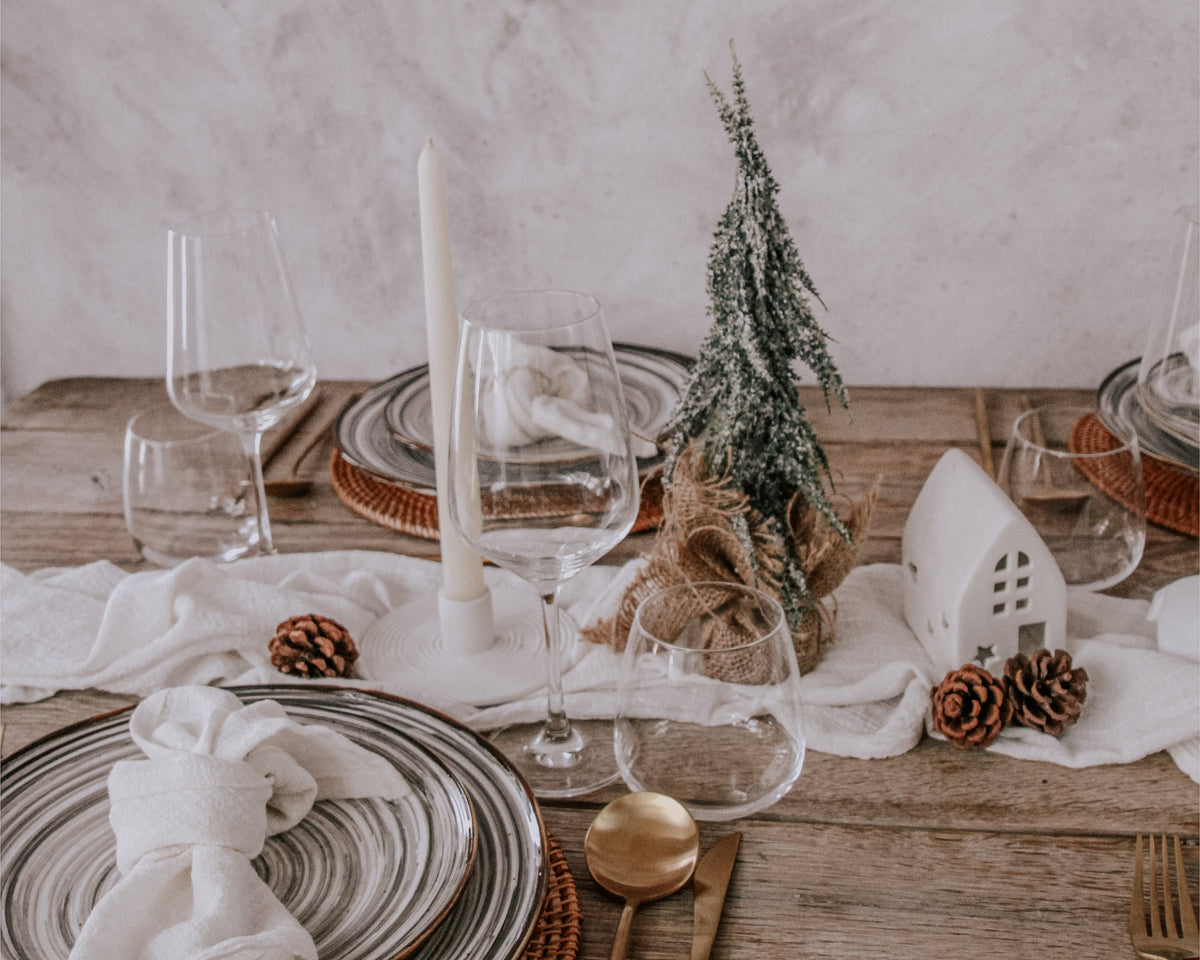 Frosted mini Christmas tree with hessian base on a festive dining table