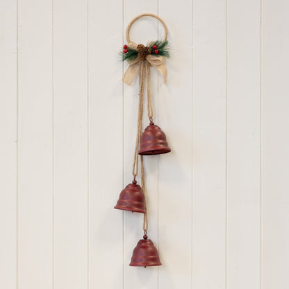 Hanging red Christmas bells decoration on a white panelled wall