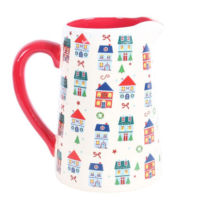 White ceramic jug with Christmas street print of colourful houses and a red handle