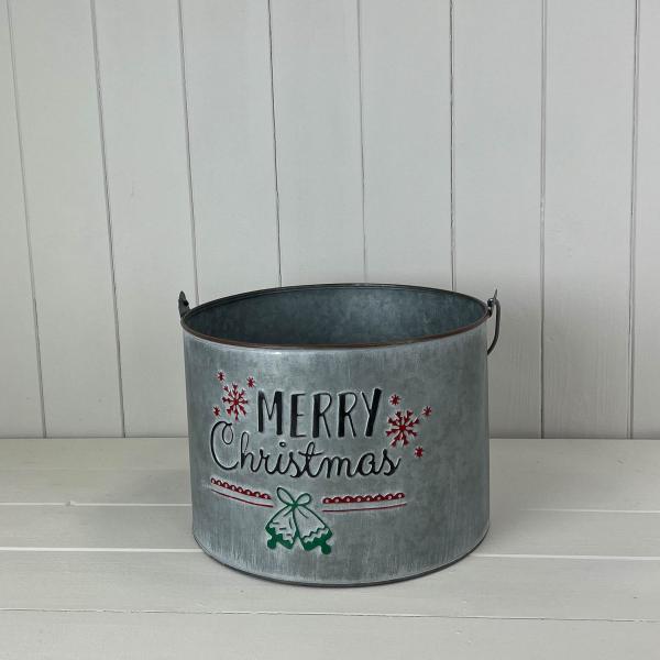 Merry Christmas metal bucket with wire handle on a white shelf