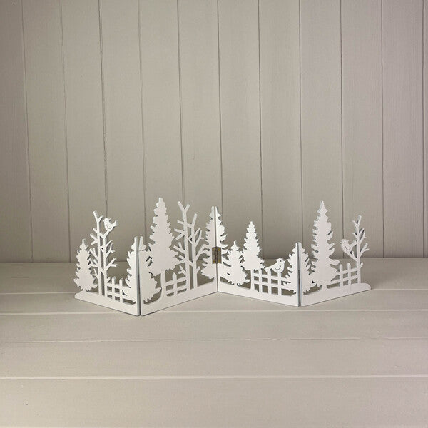 White cut-out wooden Christmas scene standing on a white shelf