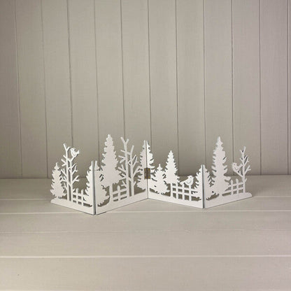 White cut-out wooden Christmas scene standing on a white shelf